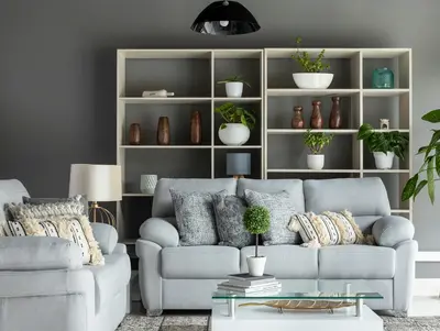 A grey sofa beside built-in shelving