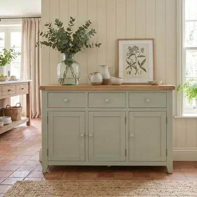 A sage green sideboard with plants