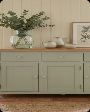 A green sideboard with dried flowers