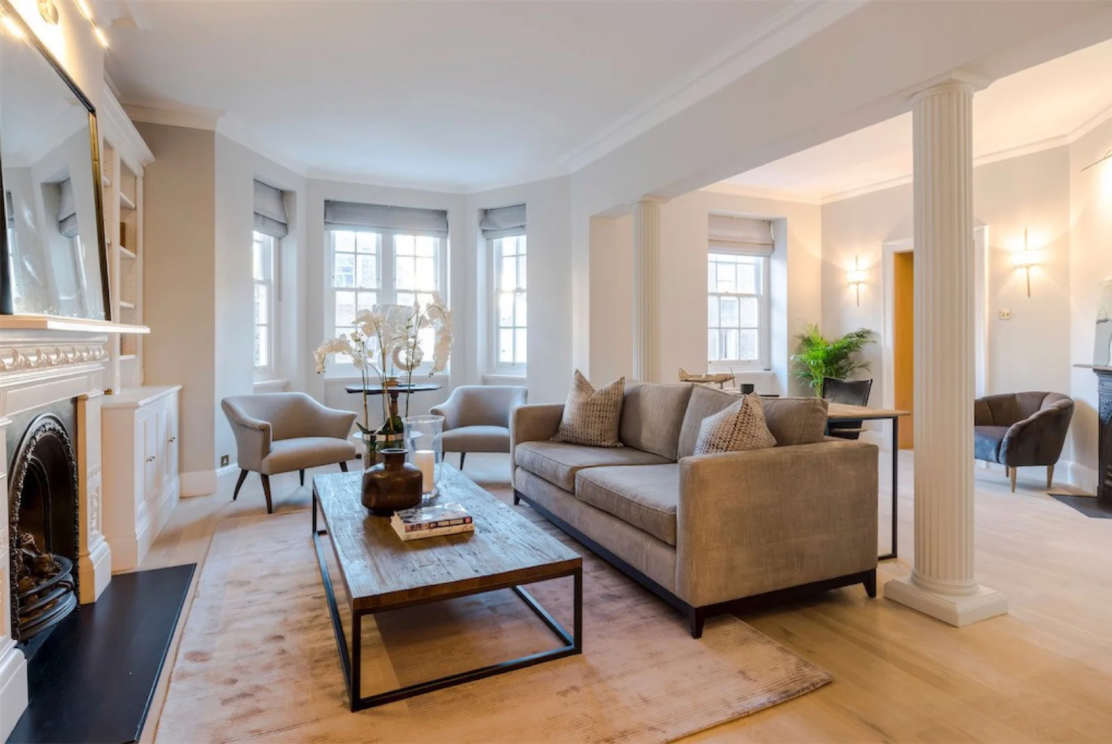 A Tamarisk sofa and armchairs styled in a bright bay-windowed room