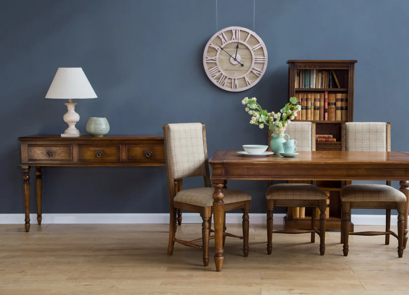 An Old Charm oak dining table and chairs in a blue-walled room